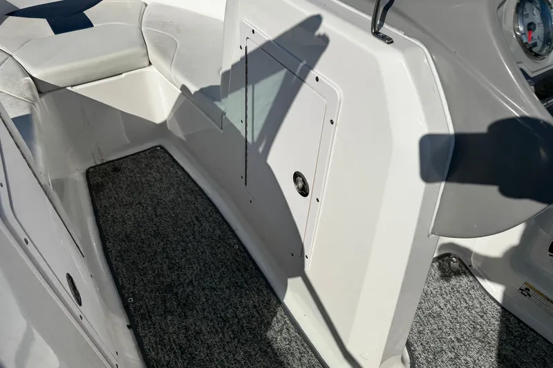 Slide: The Image of Interior view of a 2015 Chaparral 19 H2O Sport boat, featuring seating and carpeted flooring. - 23