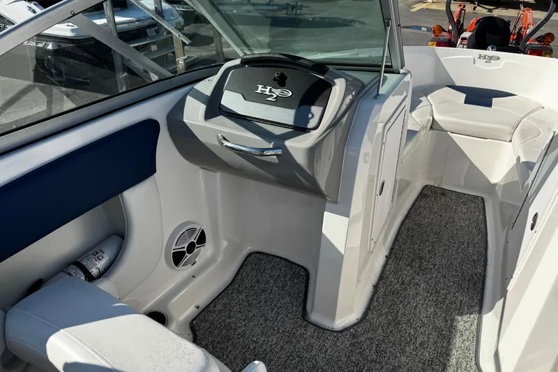Slide: The Image of Interior of a 2015 Chaparral 19 H2O Sport boat, featuring seating and dashboard. - 31