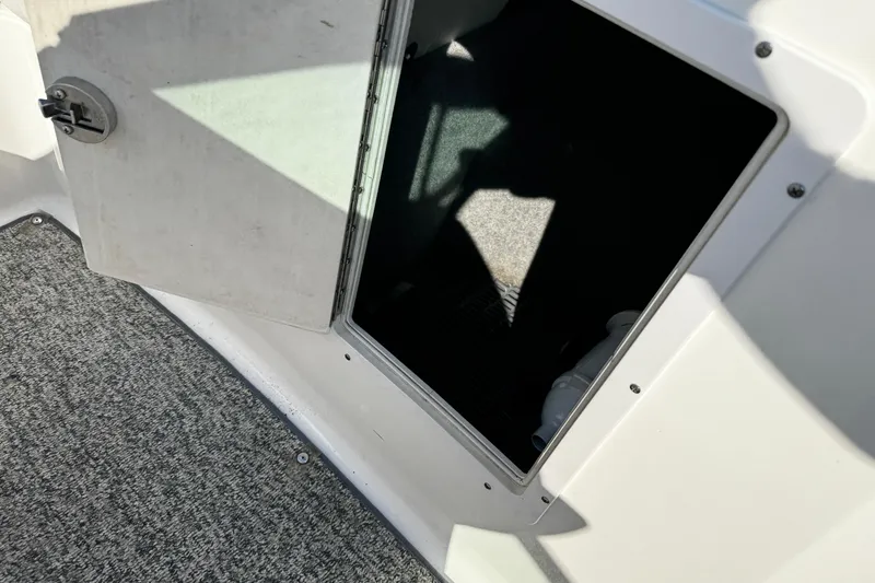 Slide: The Image of Open storage compartment on 2015 Chaparral 19 H2O Sport boat, featuring carpeted flooring. - 35