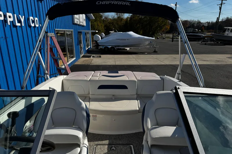Slide: The Image of 2015 Chaparral 19 H2O Sport boat interior with seating, parked outside a blue building. - 40