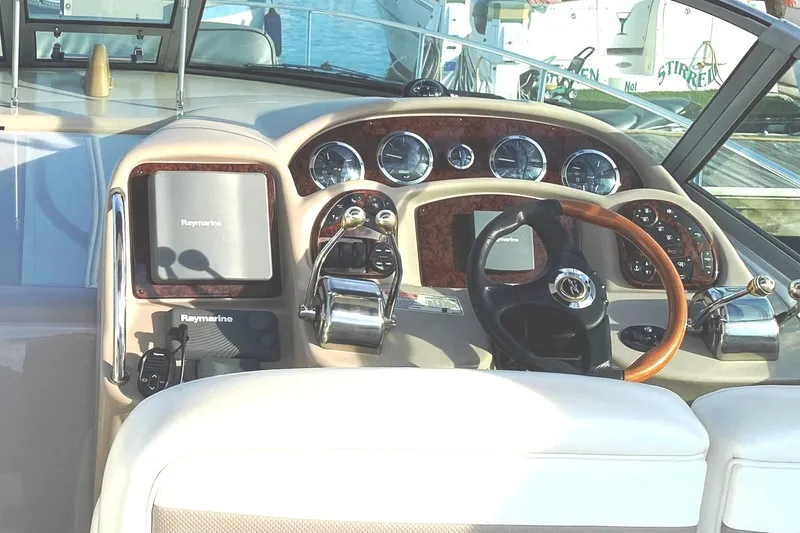 Slide: The Image of 2003 Sea Ray Sundancer 320 yacht docked in a marina under clear blue skies. - 2