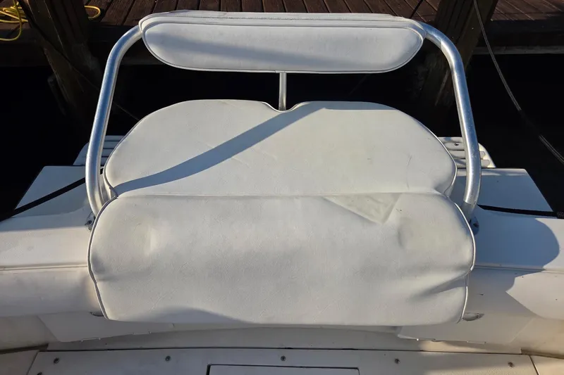 Slide: The Image of White cushioned seat on a 2000 SeaVee 290B boat, docked at a marina. - 13