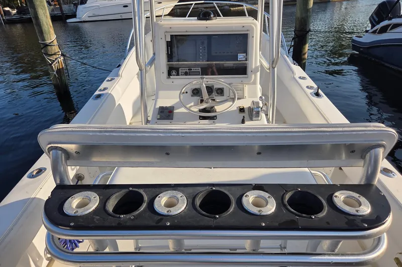 Slide: The Image of 2000 SeaVee 290B boat console with steering wheel and rod holders at marina. - 14