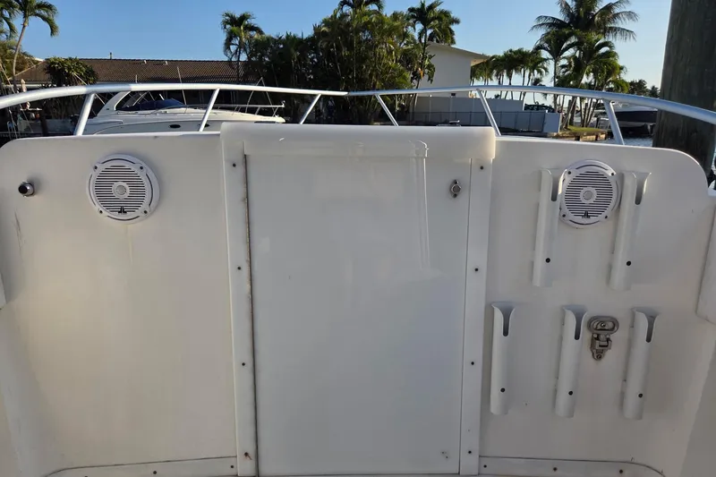 Slide: The Image of 2000 SeaVee 290B boat deck with speakers and rod holders, surrounded by palm trees. - 22