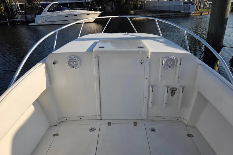 Slide: The Image of 2000 SeaVee 290B boat deck with rod holders and speakers, docked near water. - 23