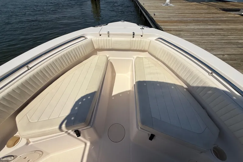 Slide: The Image of 2011 Grady-White Fisherman 209 boat interior with cushioned seating near dock. - 26