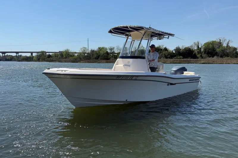 Slide: The Image of 2011 Grady-White Fisherman 209 boat on calm water, with a person at the helm. - 3