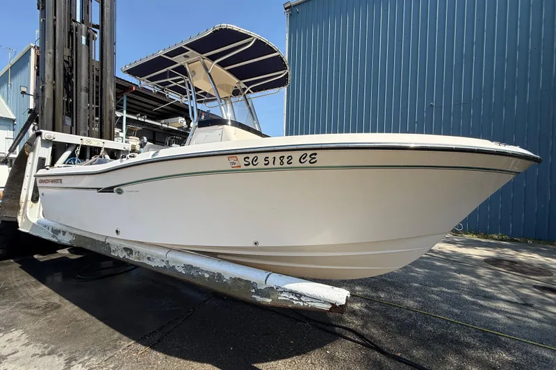 Slide: The Image of 2011 Grady-White Fisherman 209 boat on a lift, blue building background. - 7