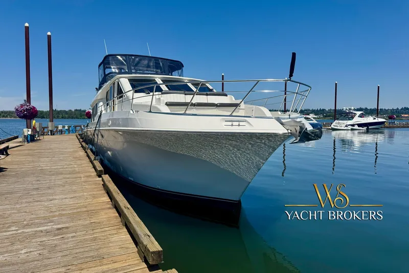 Slide: The Image of Navigator 6300 Classic Pilothouse yacht docked at marina, clear blue sky, 2000 model. - 34