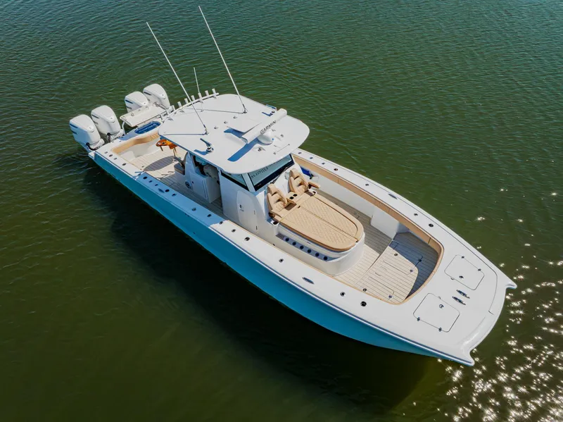 Slide: The Image of 2025 Freeman 38 boat on calm water, featuring sleek design and multiple outboard engines. - 10