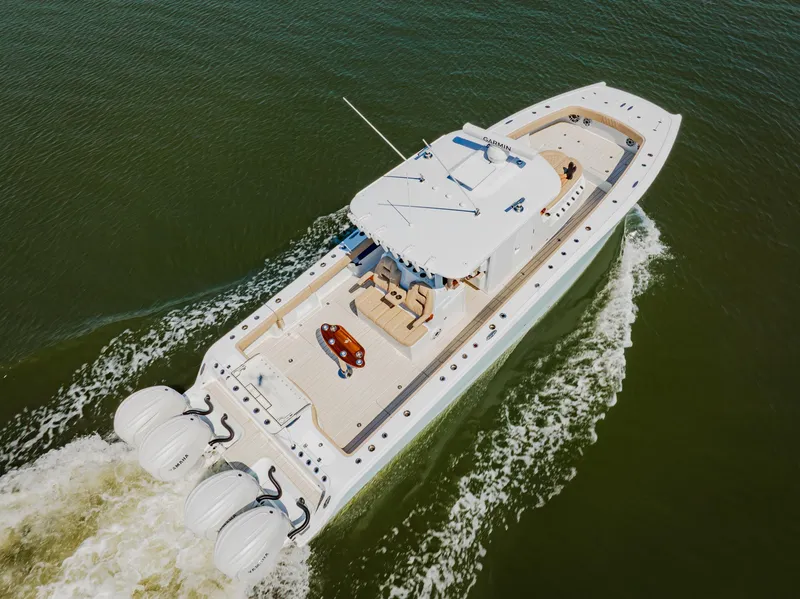 Slide: The Image of Aerial view of 2025 Freeman 38 boat cruising on water with triple outboard engines. - 14