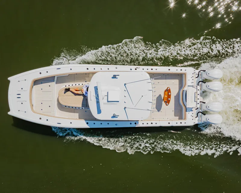 Slide: The Image of Aerial view of 2025 Freeman 38 boat cruising on water with sunbather on deck. - 15