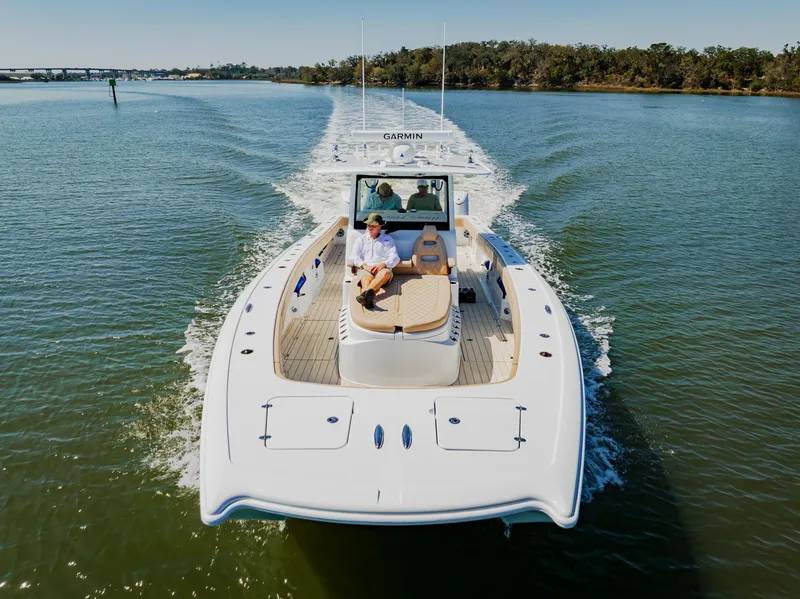 Slide: The Image of 2025 Freeman 38 boat cruising on a calm river with passengers onboard. - 17