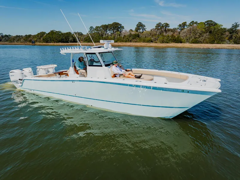 Slide: The Image of 2025 Freeman 38 boat cruising on a calm lake with two people onboard. - 2