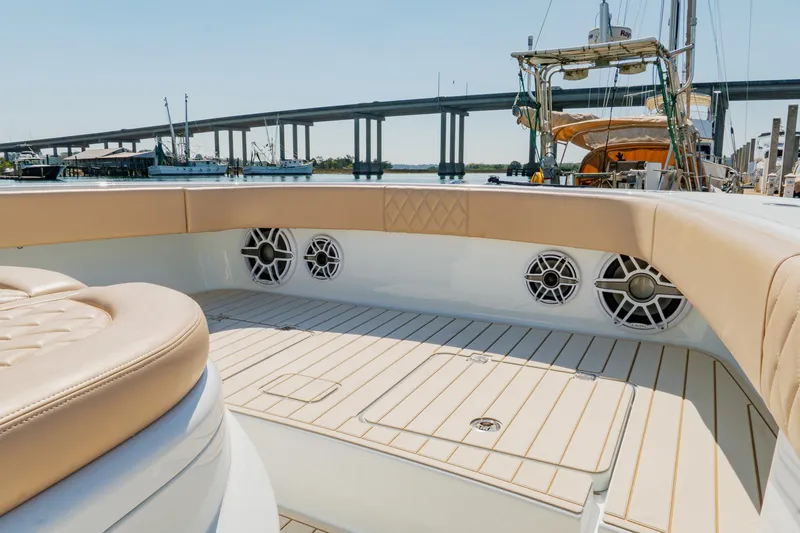 Slide: The Image of 2025 Freeman 38 boat interior with beige seating and speakers, docked near a bridge. - 31