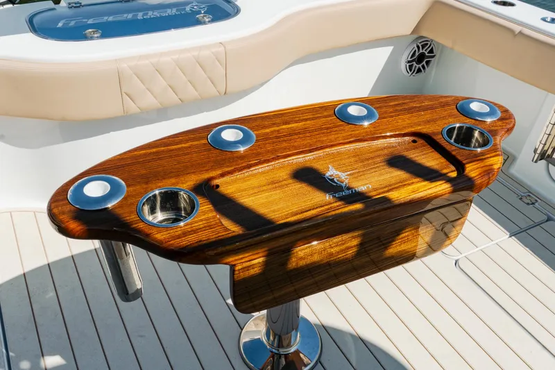 Slide: The Image of Luxurious Freeman 38 boat interior with polished wood table, cup holders, and modern design, 2025 model. - 37