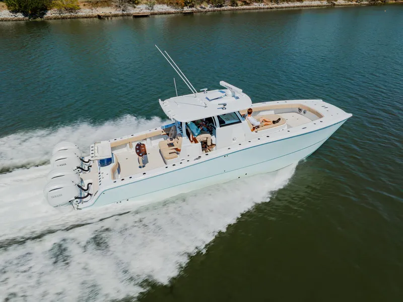 Slide: The Image of 2025 Freeman 38 boat cruising on a calm river with multiple outboard engines. - 4