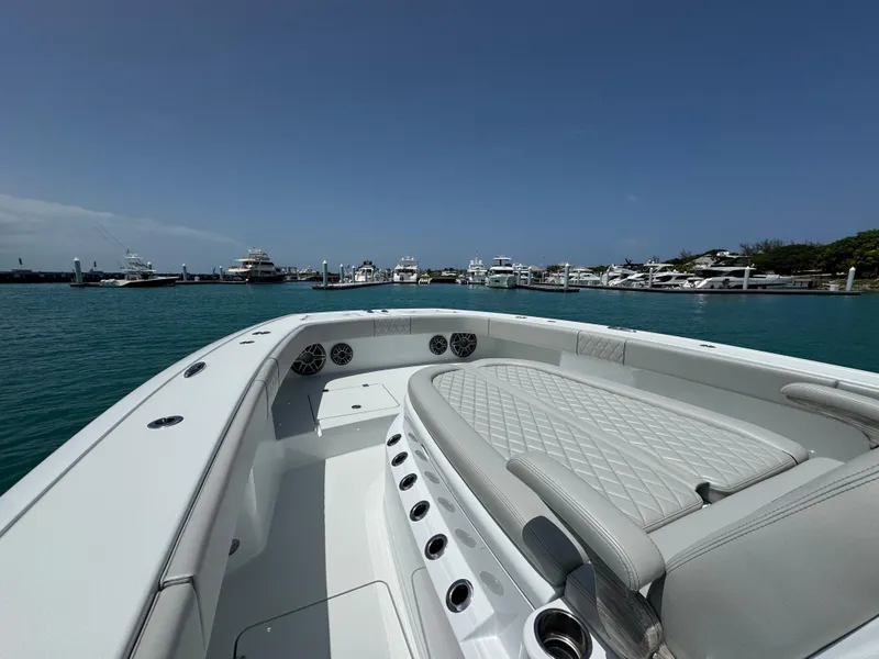 Slide: The Image of 2025 Freeman 38 boat with luxurious seating, docked in a marina under clear blue skies. - 19