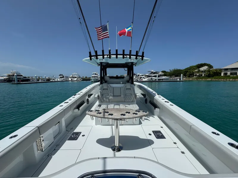 Slide: The Image of Freeman 38 boat, 2025 model, docked in a marina with flags and clear blue water. - 23