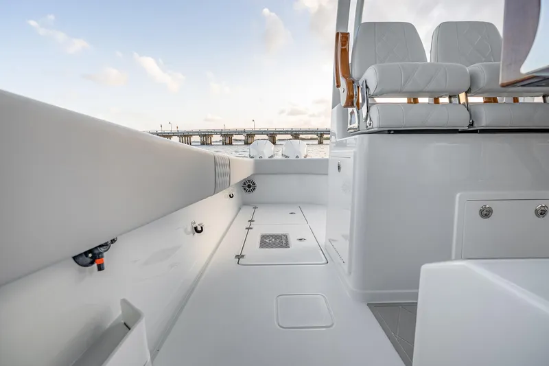 Slide: The Image of 2026 Freeman 38 boat interior with white seating and sleek design, near a bridge. - 60