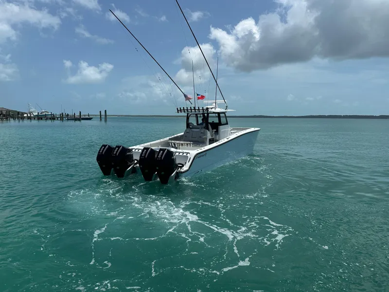 Slide: The Image of 2025 Freeman 38 boat cruising on turquoise waters under a partly cloudy sky. - 7