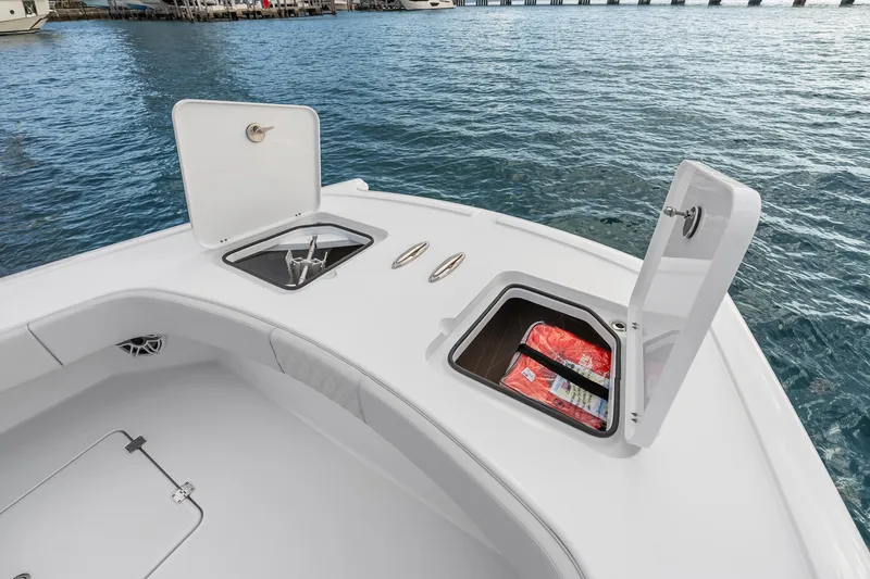 Slide: The Image of 2026 Freeman 38 boat deck with open storage compartments on calm water. - 72