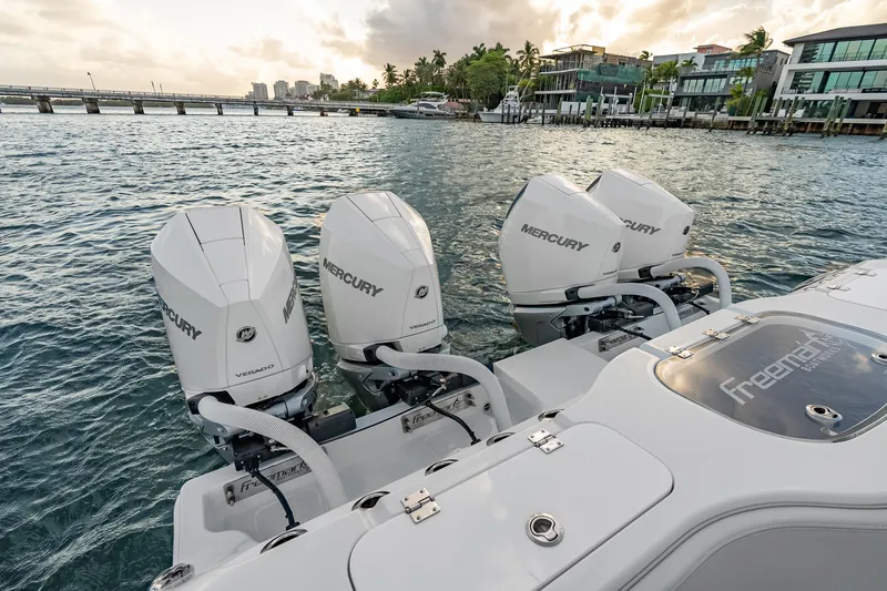 Slide: The Image of 2026 Freeman 38 boat with four Mercury Verado engines on a scenic waterfront. - 75