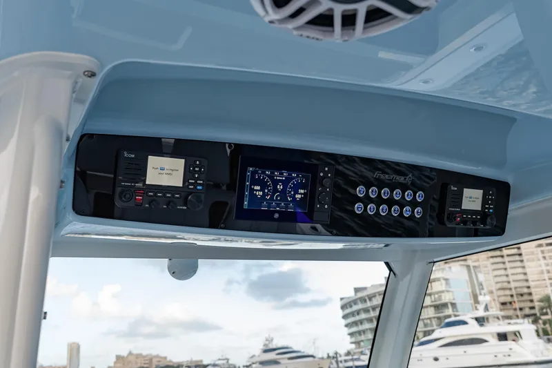 Slide: The Image of 2026 Freeman 38 boat dashboard with advanced navigation and control systems, docked near luxury yachts. - 80