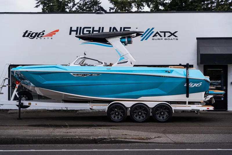 Slide: The Image of 2026 Tigé Ultré 25ZX boat on trailer outside surf boat shop. - 3