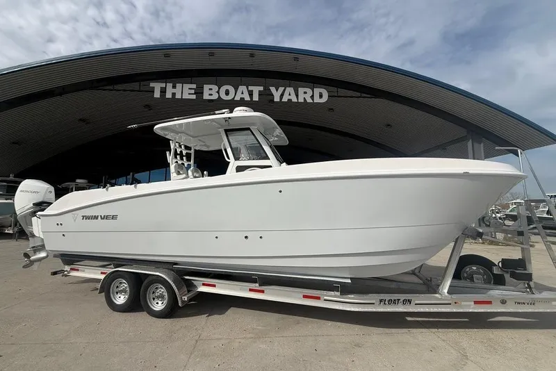Slide: The Image of 2026 Twin Vee 280 GFX2 CC boat on trailer at dealership, under cloudy sky. - 11