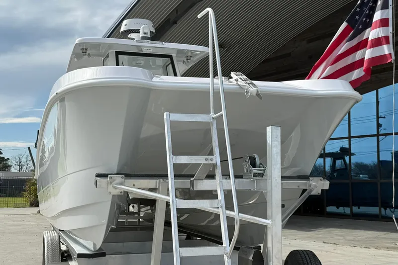 Slide: The Image of 2026 Twin Vee 280 GFX2 CC boat on trailer, American flag in background. - 3