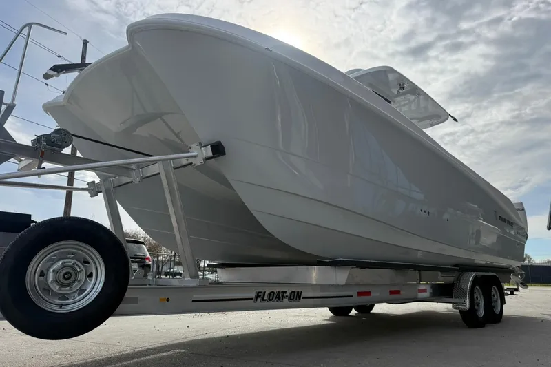 Slide: The Image of 2026 Twin Vee 280 GFX2 CC boat on trailer under cloudy sky. - 4