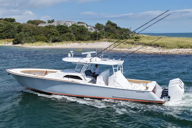 Slide: The Image of 2023 Valhalla Boatworks V-46 cruising near a scenic shoreline. - 1