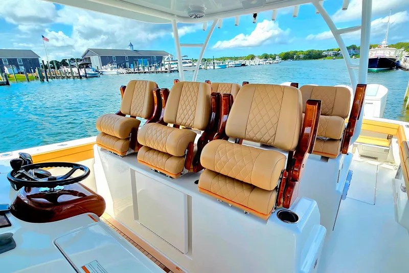 Slide: The Image of 2023 Valhalla Boatworks V-46 interior with luxurious seating and scenic marina backdrop. - 30