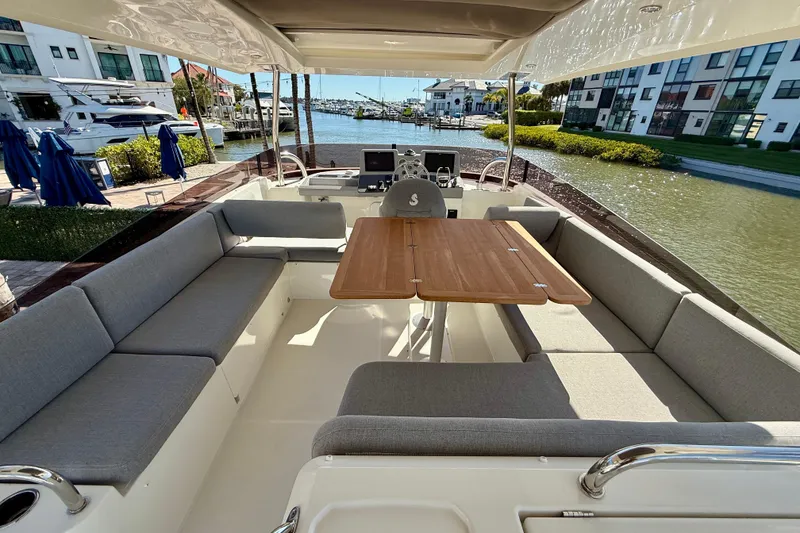 Slide: The Image of Luxurious 2023 Beneteau Swift Trawler 48 with spacious outdoor seating and wooden table. - 10