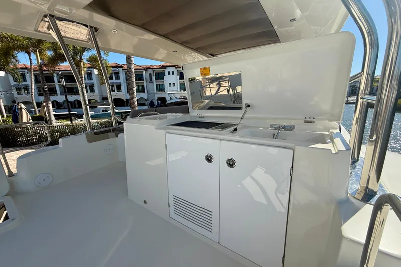 Slide: The Image of Outdoor kitchen area on 2023 Beneteau Swift Trawler 48 yacht, featuring sink and storage. - 13