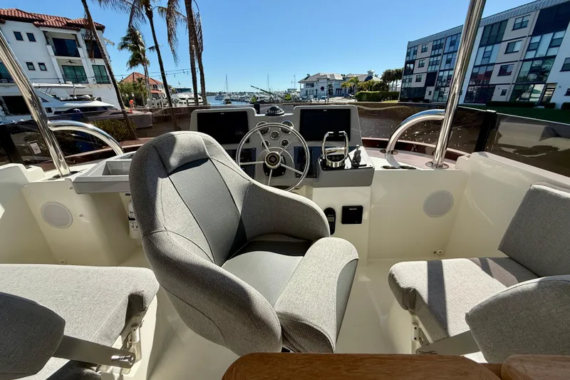 Slide: The Image of Interior view of 2023 Beneteau Swift Trawler 48 helm with modern controls and seating. - 15