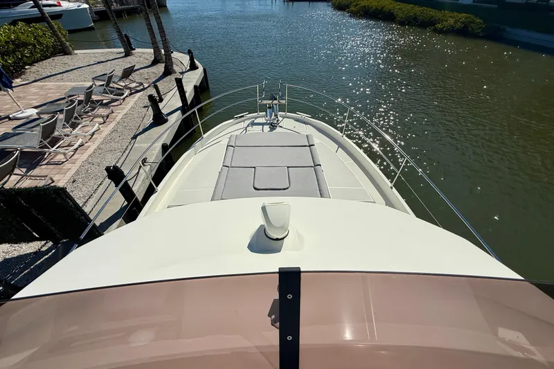 Slide: The Image of 2023 Beneteau Swift Trawler 48 docked, showcasing spacious deck and serene waterfront view. - 19