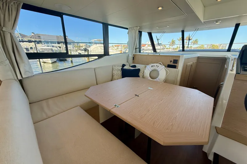 Slide: The Image of Interior of 2023 Beneteau Swift Trawler 48 with dining area and waterfront view. - 28