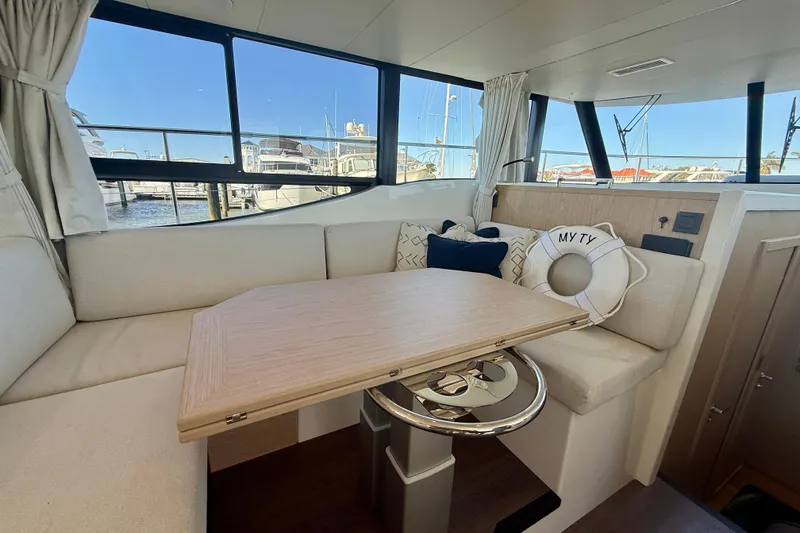 Slide: The Image of Interior of 2023 Beneteau Swift Trawler 48 with cozy seating and wooden table. - 29
