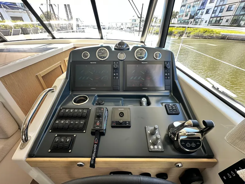 Slide: The Image of 2023 Beneteau Swift Trawler 48 helm with dual screens and control panel. - 32