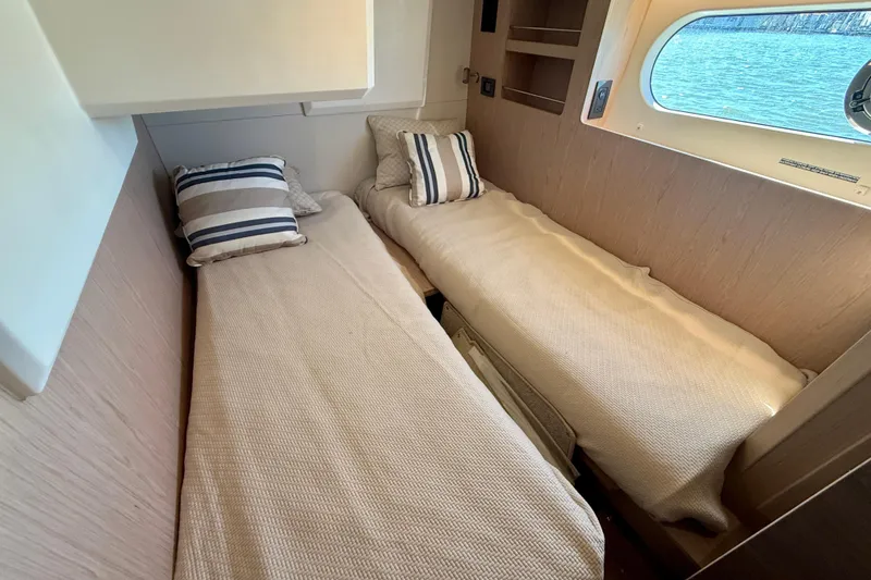 Slide: The Image of Interior cabin of 2023 Beneteau Swift Trawler 48 with twin beds and nautical decor. - 39