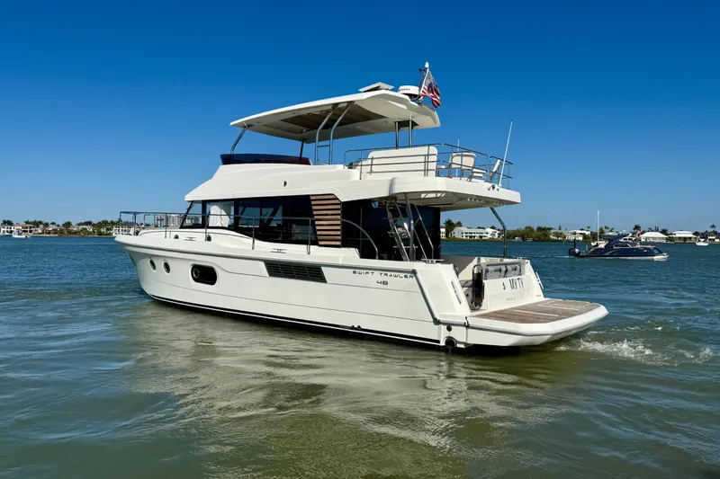 Slide: The Image of 2023 Beneteau Swift Trawler 48 cruising on a sunny day in calm waters. - 4