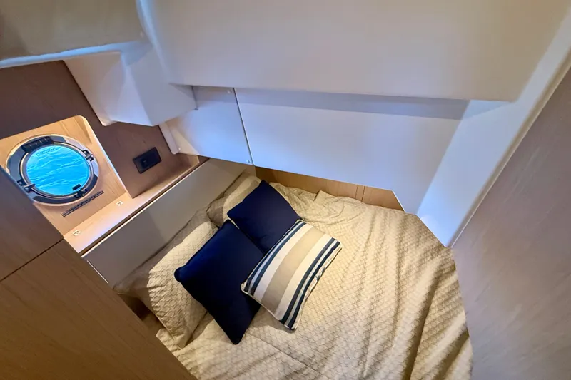 Slide: The Image of Cozy cabin interior of 2023 Beneteau Swift Trawler 48 with nautical-themed bedding. - 40