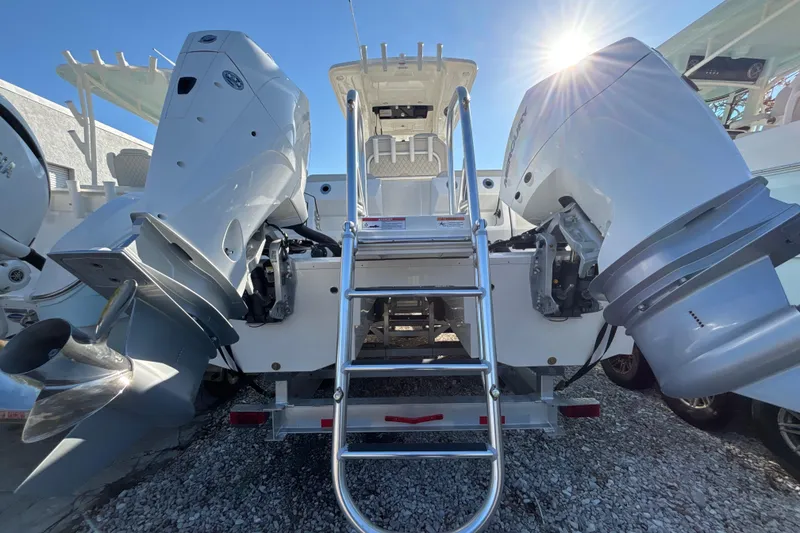 Slide: The Image of 2026 World Cat 265 CC-X boat with dual outboard engines and ladder, sunlit background. - 12