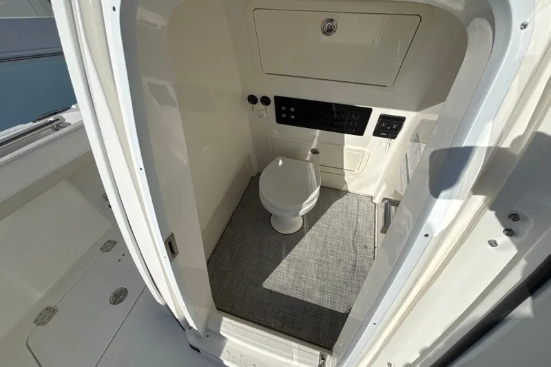 Slide: The Image of 2026 World Cat 265 CC-X boat interior with compact marine toilet and control panel. - 4