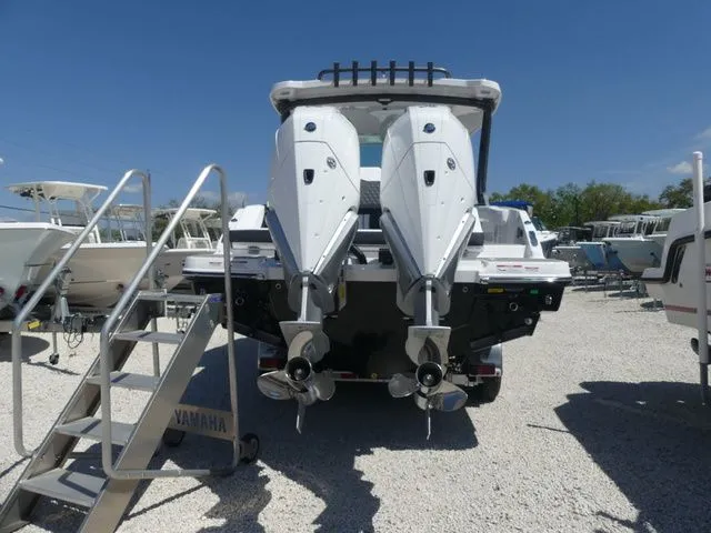 Slide: The Image of 2026 Monterey Elite 30 OB with dual outboard engines on gravel lot. - 4