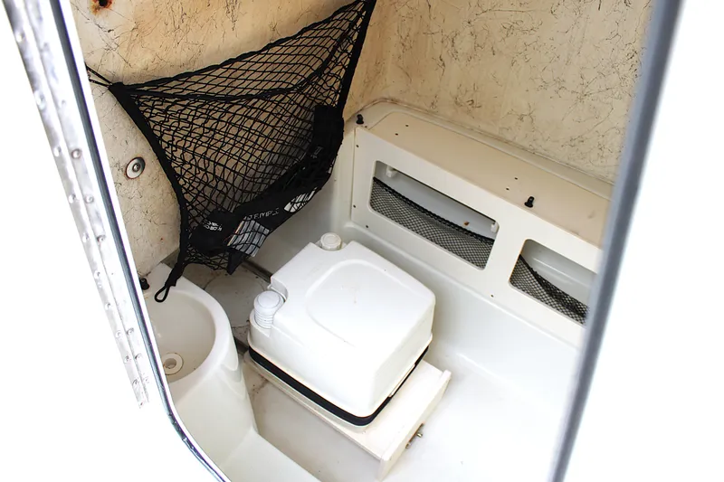 Slide: The Image of Interior of 2008 Sailfish 2660 CC boat featuring compact marine toilet setup. - 12