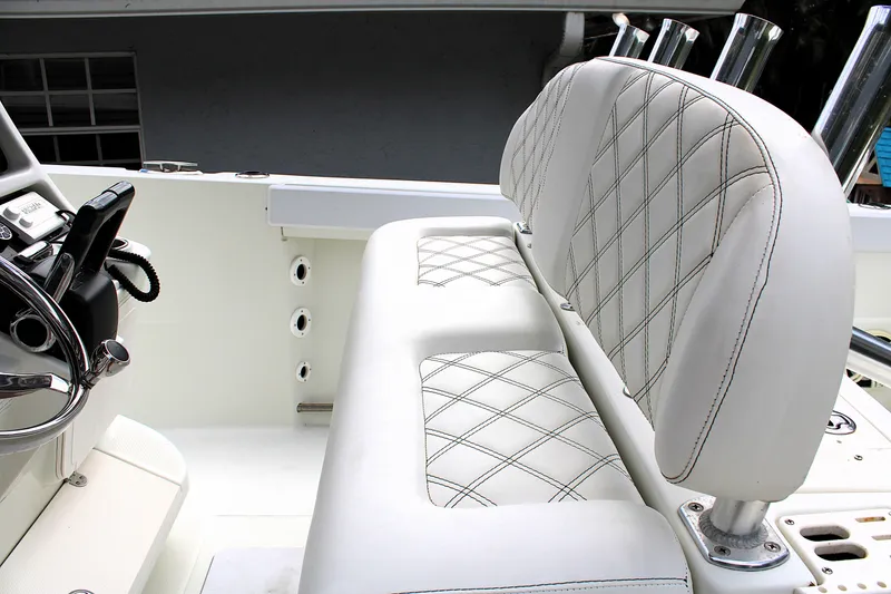 Slide: The Image of 2008 Sailfish 2660 CC boat interior with white diamond-stitched seating and steering wheel. - 22
