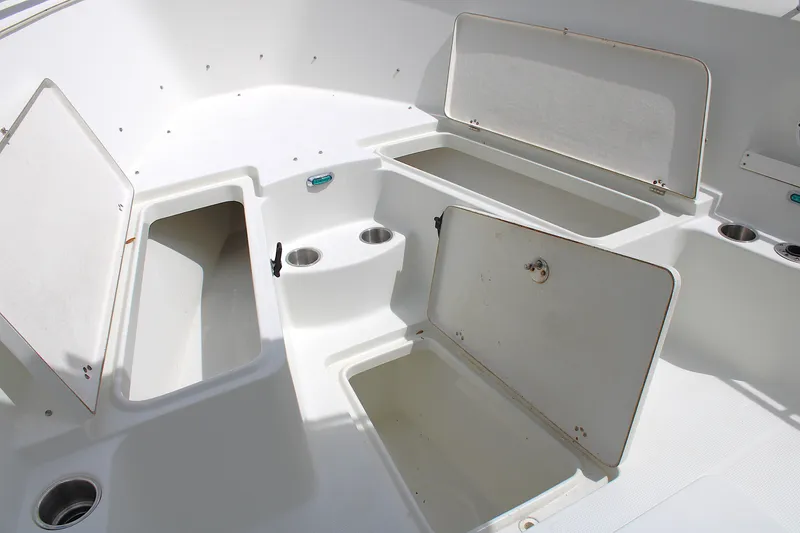 Slide: The Image of 2008 Sailfish 2660 CC boat storage compartments and cup holders in white interior. - 33
